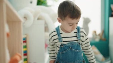 Beyaz çocuk anaokulunda oyuncaklarla oynuyor.