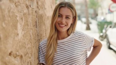 Young blonde woman smiling confident looking to the side at street