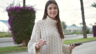 Genç, güzel İspanyol kadın sokakta dans eden müzik dinliyor.