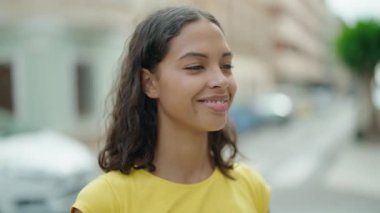 Young african american woman smiling confident looking to the side at street
