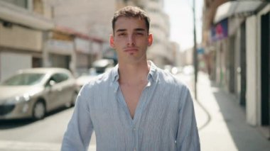 Latin kökenli genç adam sokağın aşağısında negatif işaret veriyor.