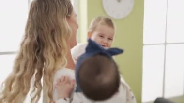 Anne ve yeni yürümeye başlayan çocuklar, evde kendilerine güvenerek duruyorlar.