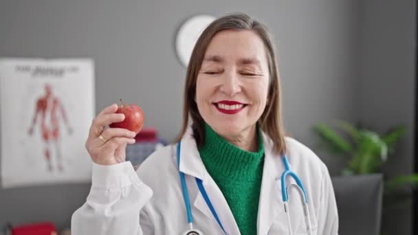 Starší Hispánská Žena Šedivými Vlasy Lékař Úsměvem Jistý Držení Jablka — Stock video