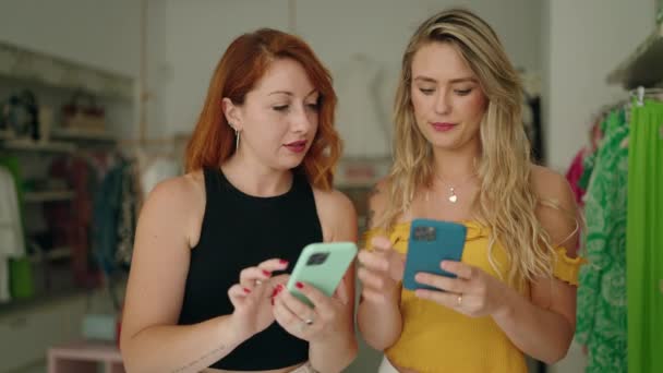 Dvě Ženy Úsměvem Jistý Pomocí Chytrých Telefonů Obchodě Oblečením — Stock video