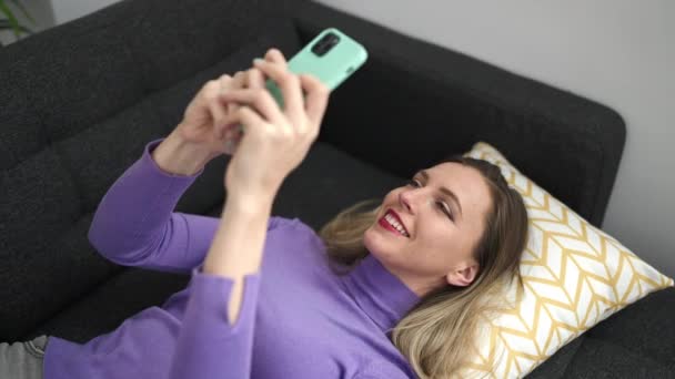 Молода Блондинка Допомогою Смартфона Лежить Дивані Вдома — стокове відео