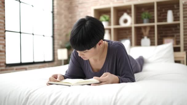 Young Chinese Woman Reading Book Lying Bed Bedroom — Stock video