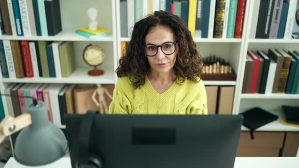 Hispanische Lehrerin Mittleren Alters Benutzt Computer Bei Unsicherem Ausdruck Bibliothek — Stockvideo