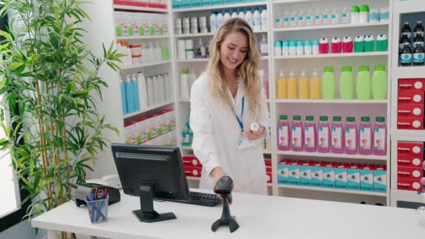 Mulher Loira Jovem Farmacêutico Digitalização Pílulas Garrafa Farmácia — Vídeo de Stock