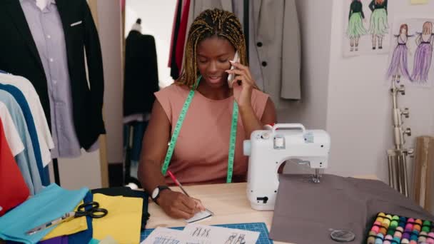 Afroamerikanische Schneiderin Spricht Auf Smartphone Und Schreibt Auf Notizbuch Schneiderei — Stockvideo