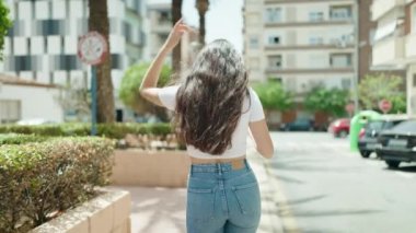 Dans eden ve parkta müzik dinleyen genç İspanyol kadın.