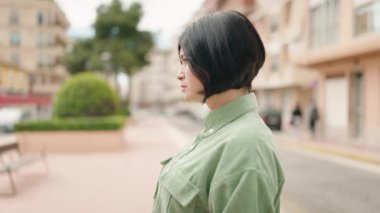 Young chinese woman with relaxed expression standing at street