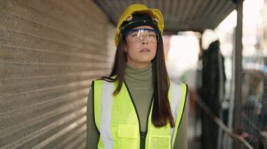 Genç İspanyol kadın mimar ciddi bir ifadeyle inşaat alanının planlarına bakıyor.