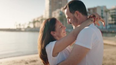 Man and woman couple hugging each other standing at beach