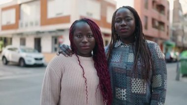 Two african american women smiling confident hugging each other at street