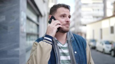 Young caucasian man speaking on the phone at street