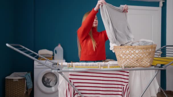 Mujer Rubia Joven Sonriendo Confiado Colgando Ropa Tendedero Sala Lavandería — Vídeos de Stock