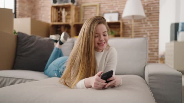 年轻的金发女人在新家用智能手机充满自信地微笑 — 图库视频影像