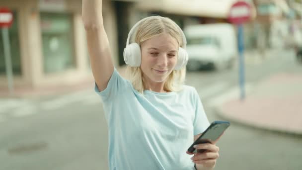 Молодая Блондинка Слушает Музыку Улице — стоковое видео
