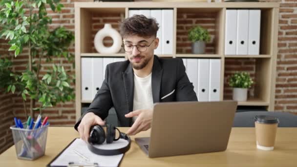 Genç Arap Adamı Ofiste Çalışan Dizüstü Bilgisayar Kulaklık Kullanıyor — Stok video