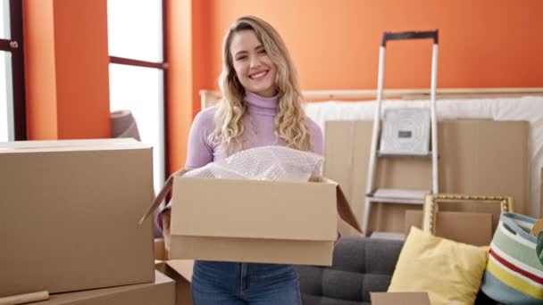 Young Blonde Woman Smiling Confident Holding Package New Home — Video