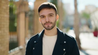 Sokakta kendinden emin gülümseyen İspanyol genç adam.