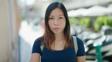 Young asian woman doing stop gesture with hand at coffee shop terrace