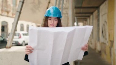 Genç İspanyol kadın mimar sokak planlarına bakıyor.