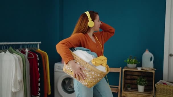 Young Redhead Woman Listening Music Holding Basket Clothes Laundry Room — Stockvideo