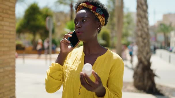 Mujer Afroamericana Joven Hablando Teléfono Inteligente Sosteniendo Píldoras Calle — Vídeo de stock