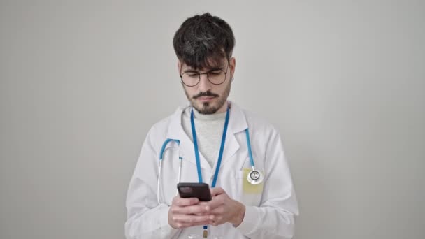 Młody Latynos Człowiek Lekarz Uśmiecha Się Pomocą Smartfona Odizolowanym Białym — Wideo stockowe