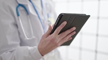Genç İspanyol doktor klinikte akıllı telefon kullanıyor.