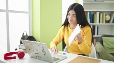 Genç, güzel İspanyol kız öğrenci kütüphanede defterini gösteren bir video mesajı alıyor.