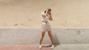 Young caucasian woman smiling confident listening to music dancing at street