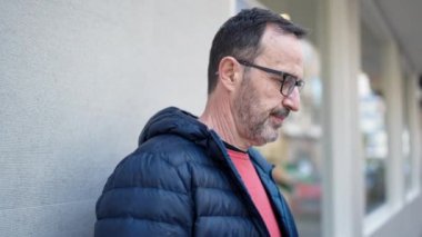 Middle age man looking to the sky at street