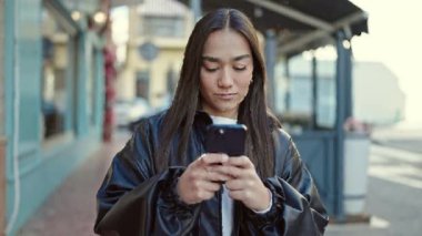 Kahve dükkanının terasında akıllı telefon kullanan, kendine güvenen, güzel İspanyol bir kadın.