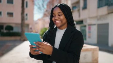 Sokakta dokunmatik ped kullanan, kendine güvenen genç Afro-Amerikan kadın.