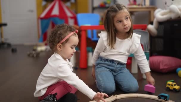 幼稚園の床に座って車と遊んでいる2人の女の子 — ストック動画