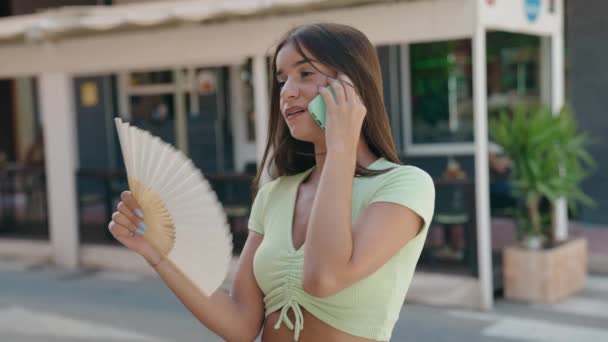 Giovane Bella Donna Ispanica Parlando Smartphone Utilizzando Ventilatore Mano Strada — Video Stock