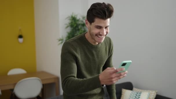 Jovem Hispânico Usando Smartphone Sentado Sofá Casa — Vídeo de Stock
