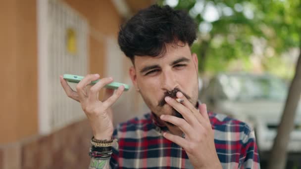 Young Hispanic Man Listening Audio Message Smartphone Smoking Street — 图库视频影像