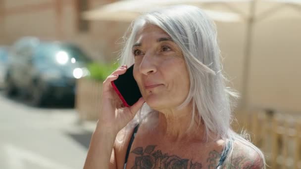 Mujer Pelo Gris Mediana Edad Sonriendo Confiada Hablando Teléfono Inteligente — Vídeo de stock