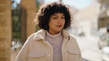 Sokakta kendine gülen genç İspanyol kadın.