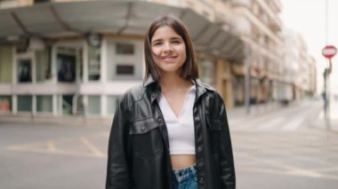 Young hispanic woman smiling confident shake hand at street
