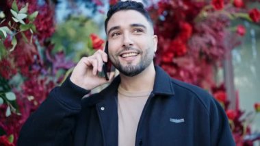 Genç Arap adam sokakta akıllı telefonuyla sesli mesaj gönderiyor.