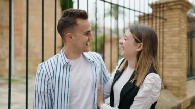 Erkek ve kadın çift sokakta birbirlerine sarılıyorlar.