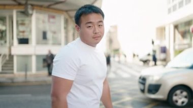 Young chinese man smiling confident standing with arms crossed gesture at street