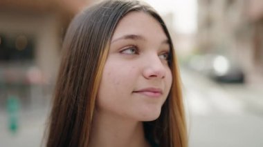 Adorable girl smiling confident looking to the camera at street
