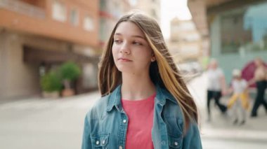 Sevimli kız gülümsüyor. Kendine güveniyor. Sokakta kameraya bakıyor.