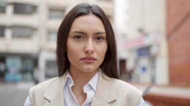 Sokakta ciddi bir ifadeyle duran genç, güzel İspanyol kadın.