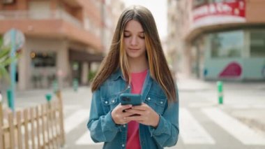 Adorable girl smiling confident using smartphone at street